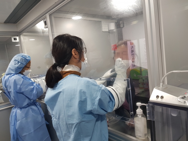성남수정보건소관계자가 이동현 검사부스에서 코로나19검사를 하고 있다.